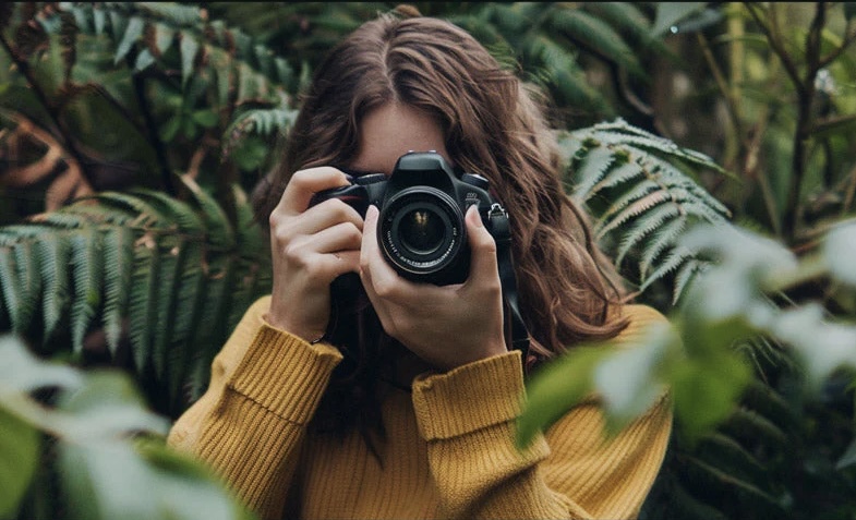 Kelsey holding camera in jungle environment