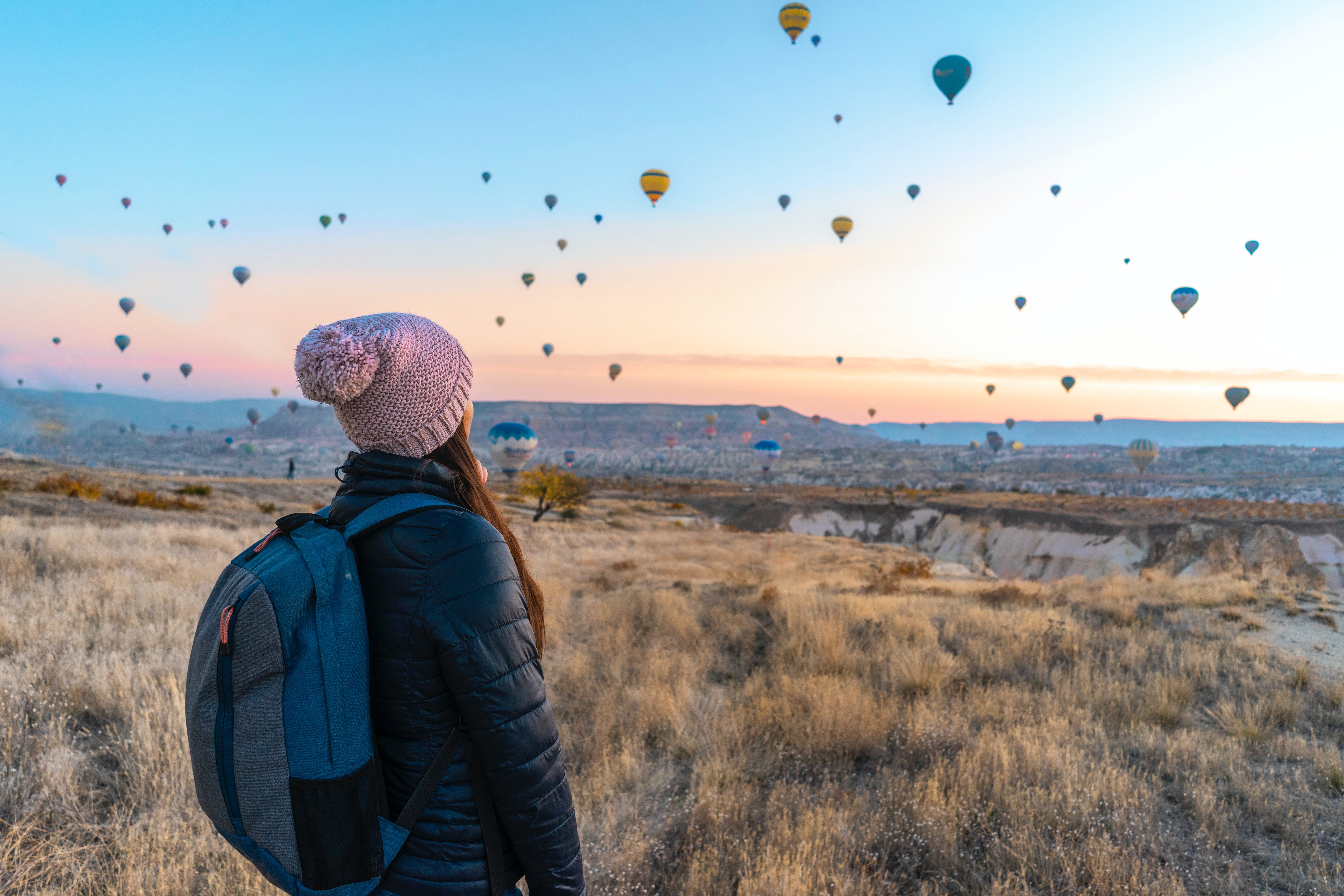 Kelsey observing landscape with hot air balloons in sky